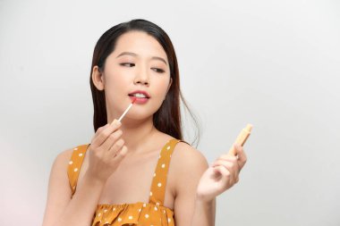 Mutlu, güzel, komik kız ruj fırçalarını elinde tutuyor. Şık makyaj modeli