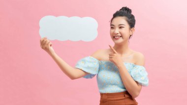Güzel genç bir kadın boş konuşma balonunu işaret ediyor.