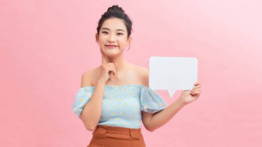 20 'li yaşlardaki kadın portresi, mürekkep arkaplanı üzerinde boş düşünce baloncuğu tutarken gülümsüyor.