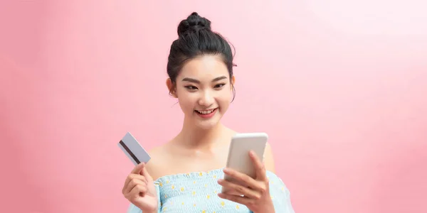 Удивлена Молодая Красивая Женщина Позирует Фоне Розовой Стены Используя Мобильный — стоковое фото