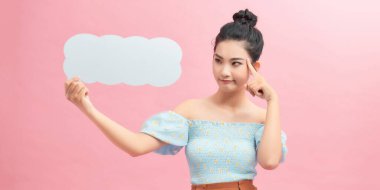 20 'li yaşlardaki kadın portresi, mürekkep arkaplanı üzerinde boş düşünce baloncuğu tutarken gülümsüyor.