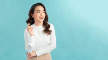 Mavi arka planda beyaz elbiseli mutlu, güzel bir kadın..