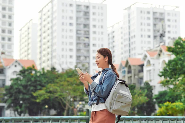 庭でスマートフォンを使用して若いアジアの女の子 — ストック写真