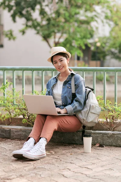 幸せな若い旅行者の女性のバックパックで座っている彼女のラップトップ 技術の概念 若者とデジタル遊牧民のライフスタイル テキストのためのコピースペース — ストック写真