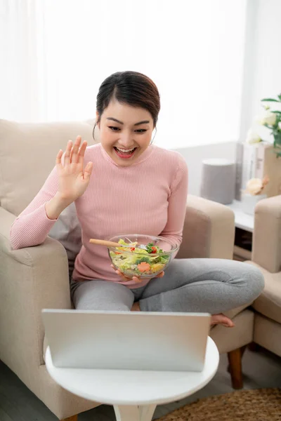 Hermosa Joven Sentada Sofá Comiendo Una Ensalada Saludable Usando Una — Foto de Stock