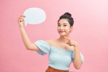 Harika bir teklif. Pembe stüdyo arka planında boş konuşma balonu tutan çok neşeli bir kız.