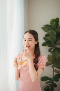 Güzel Asyalı kadınlar evde sağlıklı beslenme için besleyici balık yağı takviyesi yiyorlar.