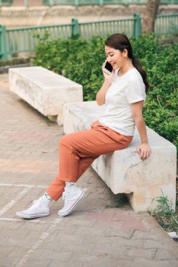 Dışarıda cep telefonuyla konuşan güzel bir kadın..