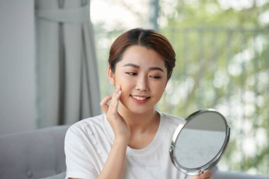 Kadın Güzellik Bakımı. Aynaya Bakan Taze Sağlıklı Cildi Olan Güzel Mutlu Genç Bir Kadın Portresi