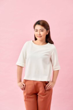 Mutlu gülümseyen genç bir kadının portresi, pembe arka planda izole edilmiş.