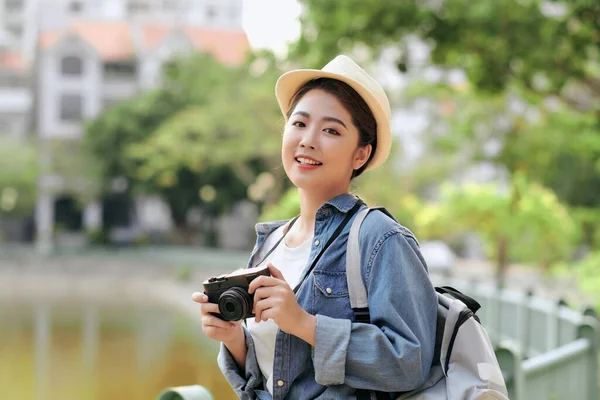 魅力的な幸せな笑顔若い大人のアジアの女性旅行者のバックパックを着用 写真旅のためのカメラの使用 — ストック写真
