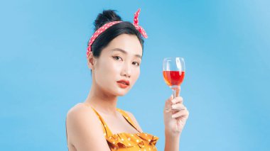 Sarı elbiseli, elinde şampanya bardağıyla neşeli genç bir kadının portresi.