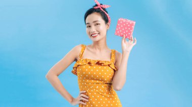 Renkli arka planda hediye kutusu olan güzel genç bir kadın.