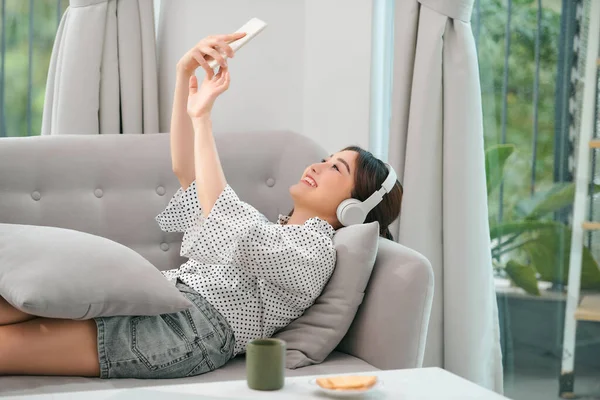 Glückliche Junge Entspannte Frau Mit Kopfhörern Die Auf Der Couch — Stockfoto