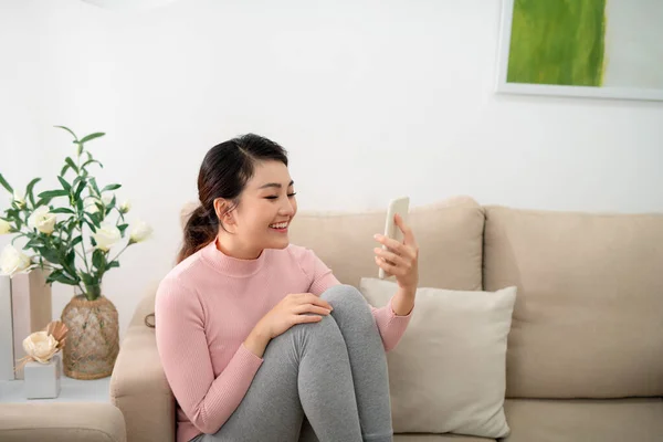 Frau Benutzt Laptop Und Handy Auf Sofa — Stockfoto