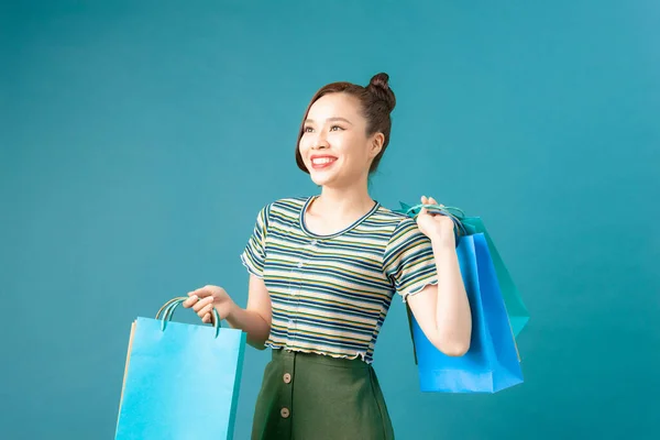 Kadın Alışveriş Çantasını Mavi Arka Planda Mutlu Bir Şekilde Alır — Stok fotoğraf