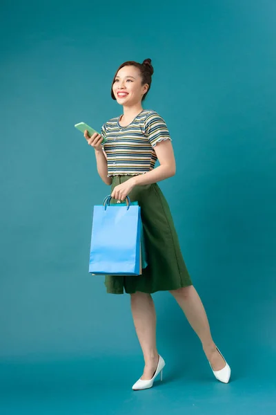 Glimlachende Jonge Aziatische Vrouw Met Winkelen Kleur Tassen Blauwe Achtergrond — Stockfoto