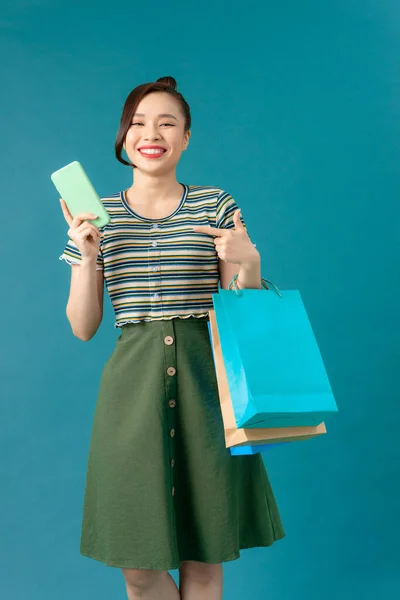 Güzel Asyalı Kadın Elinde Alışveriş Çantaları Cep Telefonuyla Mutlu Bir — Stok fotoğraf