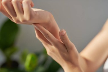 Çekici genç bir kadın evde el kremi sürüyor.