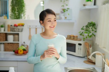 Evde süt içen güzel bir kadın.