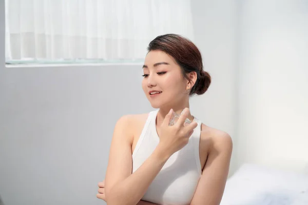 Joven Hermosa Mujer Sentada Contra Espejo Aplicando Perfume — Foto de Stock