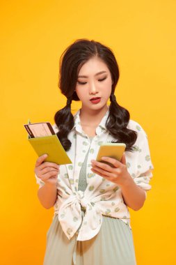 Klasik kameralı Asyalı kadın mutlu ve sarı arka planda gülümsüyor.