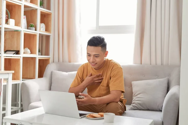 远程工作 年轻英俊的男子坐在他现代的家沙发上与朋友们进行视频通话 — 图库照片