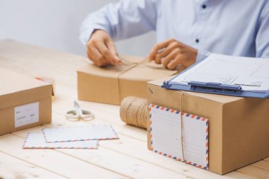 Genç işletme sahibi karton kutu paketliyor. İnternetten alışveriş hakkında.