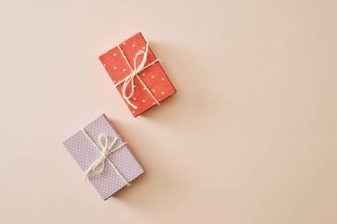 Pastel renk arkaplanındaki üst görünümde paketlenmiş kutularda hediyeleri olan düz tabaka