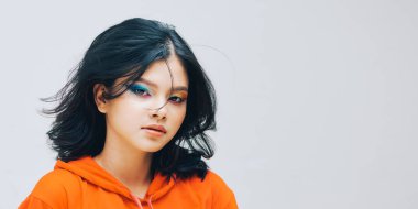 Ciltli, kıvırcık saçlı, parlak makyajlı güzel bir kadın.