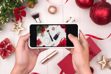 Telefon çekimi fotoğraf Noel holding eller Kozmetik ürünlerin olun