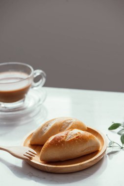 Beyaz arka planda sütlü çay ile kahvaltı ekmeği..
