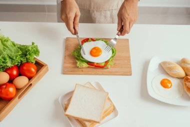 Tahtada servis edilen lezzetli kızarmış yumurtalı sandviç.