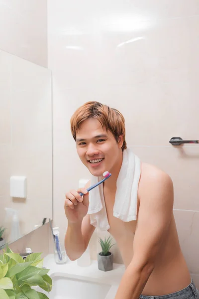 アジア人の男性が浴室で朝に歯を磨く — ストック写真