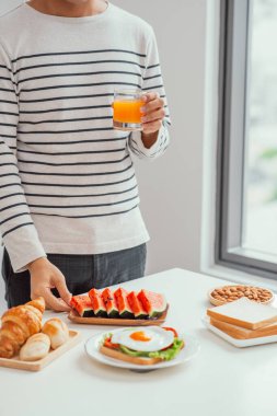 Adam kahvaltıda taze karpuz ve ekmek yiyor.