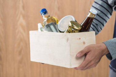 Gönüllü bağış kutusu ahşap arka plan üzerinde gıda maddeleri ile