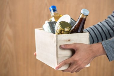 Gönüllü bağış kutusu ahşap arka plan üzerinde gıda maddeleri ile
