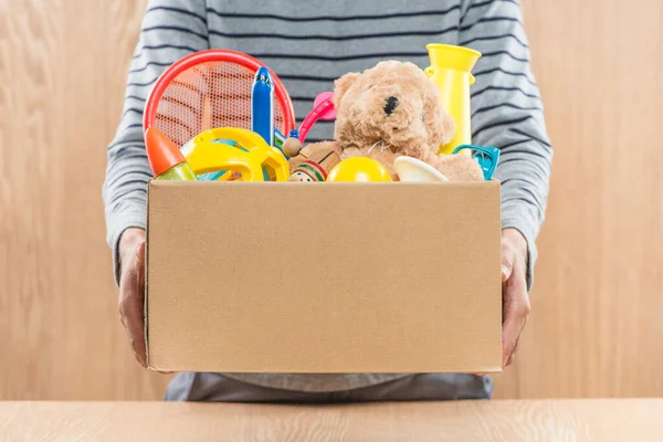 Masculino Voluntário Segurando Caixa Doação Com Brinquedos Antigos — Fotografia de Stock