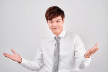 Mutlu Asyalı adam beyaz arka planda birini selamlıyor. Kameraya bakıyorum.