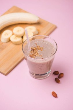 Muz smoothie muz, süt, beyaz masa, üstten görünüm, yatay, seçici odak cam bardaklarda badem
