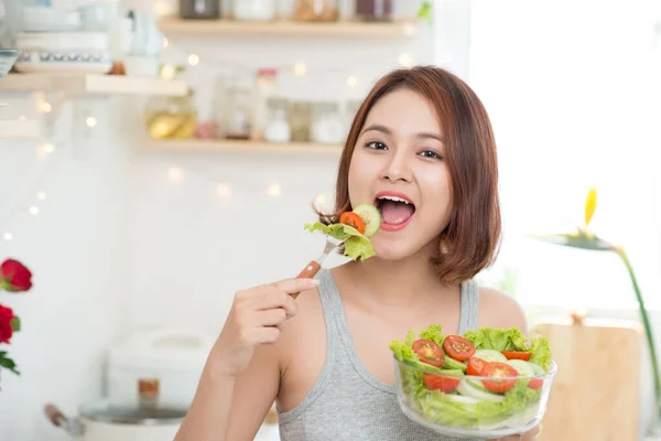 美しい若いアジア女の子はサラダを食べるします 健康に良い食べ物を食べて笑顔の幸せな女の子 — ストック写真