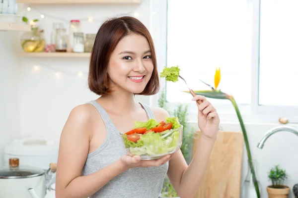 美しい若いアジア女の子はサラダを食べるします 健康に良い食べ物を食べて笑顔の幸せな女の子 — ストック写真