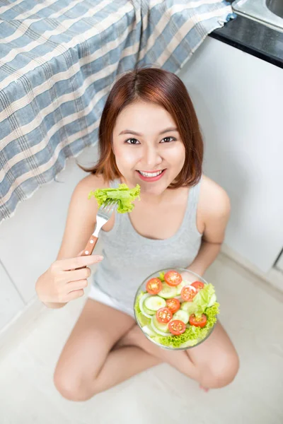 美しい若いアジア女の子はサラダを食べるします 健康に良い食べ物を食べて笑顔の幸せな女の子 — ストック写真