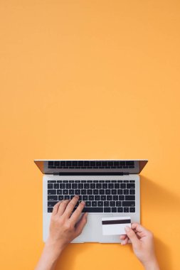 Bir adam internetteki malların parasını kredi kartı ve dizüstü bilgisayarla ödeyecek. Çevrimiçi alışveriş kavramı.