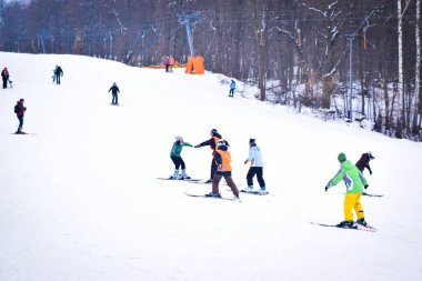 Kiev, Ukrayna - 18 Şubat 2018: Kayakçılar kayak asansörüyle kar kayağı yapıyorlar. Bir eğitmenle kayak öğretmek. Kış eğlencesi Kayak pistinde kayak yapmak..
