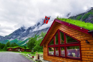Çatısı yeşil çimlerle kaplı otantik bir ev ve popüler Troll Stair ya da Trollstigen Serpentine yolunun dibinde Norveç bayrağı popüler bir turizm merkezi. Daha fazla og Romsdal, Norveç.