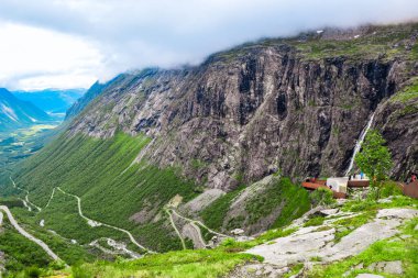 Trol stijeni ya da Trol Merdiveni 'ne bakış açısı, 11 saç tokasından dolayı popüler bir turizm merkezi olan yılansı dağ yolu dağ yamacına doğru eğiliyor. Daha fazla og Romsdal, Norveç.