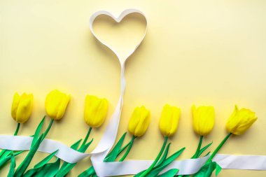 Güneşli sarı çiçek aranjmanı. Sarı kağıtta kalpleri olan sarı, taze laleler. Sevgililer Günü için tebrik kartı, Anneler Günü ya da diğer tatiller için. Seçici odaklanma. Düz yatıyordu. Boşluğu kopyala.