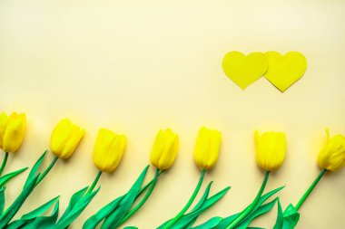 Güneşli sarı çiçek aranjmanı. Sarı kağıtta kalpleri olan sarı, taze laleler. Sevgililer Günü ya da diğer tatiller için tebrik kartı. Seçici odaklanma. Düz yatıyordu. Boşluğu kopyala.