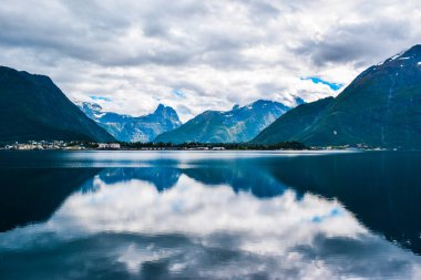 Romsdal Fjord 'a ya da Romsdalsfjord' a bulutlu havada yansıyan güzel dağ manzarası. Romsdal ilçesi. Andalsnes şehrinden görüntü. Norveç 'e yaz yolculuğu macerası.